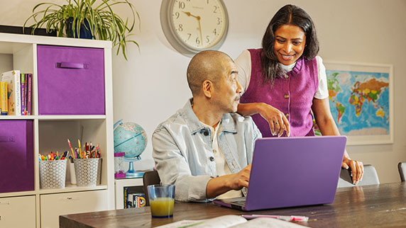Two people looking at a laptop